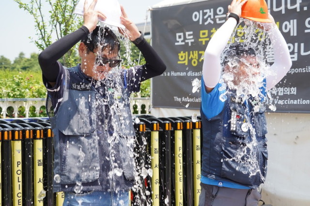 건설노조원들이 폭염 대책 법제화를 촉구하는 얼음물 붓기 퍼포먼스를 하고 있다 사진민주노총 건설노조