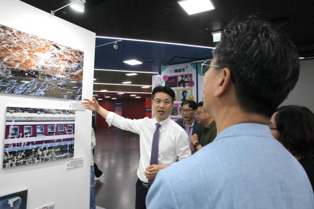 Professor Kang Dong-wan who provided photos for the exhibition Spotlighting North Korean human rights through pictures explains the photos to visitors at Seoul City Halls Citizens Hall on July 8 2024 AJU PRESS Han Jun-gu