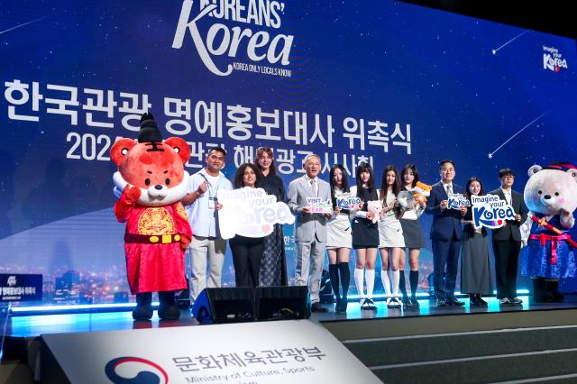 The members of K-pop girl band NewJeans pose for a photo with Minister of Culture Sports and Tourism Yu In chon 5th from left at an event in Seoul on July 11 2024 AJU PRESS Kim Dong-woo