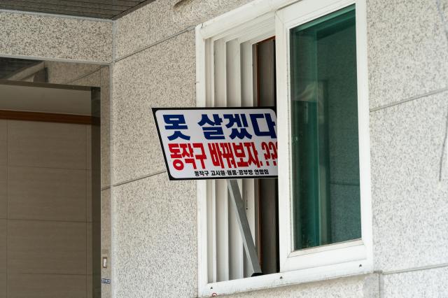 A placard hangs on a studio apartment building undergoing demolition in Noryangjin Seoul on July 12 2024 The sign reflects ongoing conflicts between residents and Dongjak District officials over urban renewal plans in this changing neighborhood AJU PRESS Park Jong-hyeok