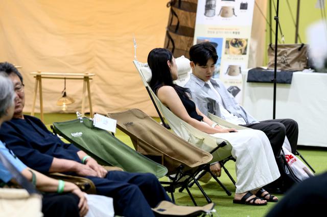 Visitors sit on camping chairs on display at the Global Outdoor Camping  Leisure Sports Fair at SETEC in Gangnam Seoul on 19 July 2024 AJU PRESS Kim Dong-woo