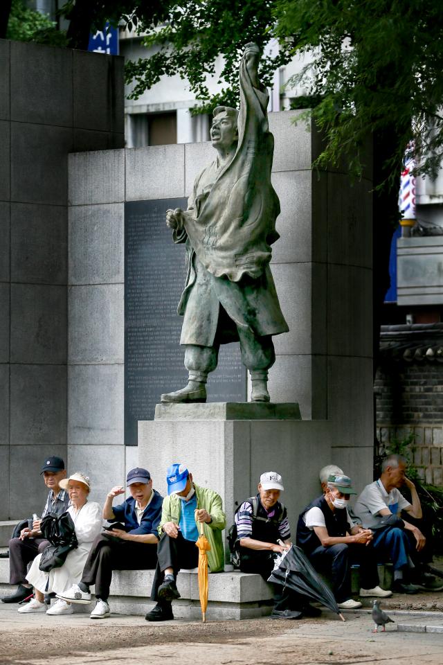 Senior citizens rest on a statue at Pagoda Park in Jongno-gu Seoul on July 23 2024 AJU PRESS Kim Dong-woo