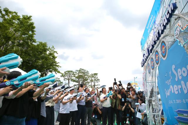 Guests shoot water guns at targets during the opening ceremony of the 2024 Seoul Summer Beach in Gwanghwamun Square Seoul on July 26 2024 AJU PRESS Han Jun-gu