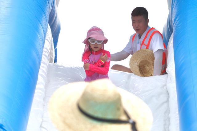 A kid slides down a water slide at the 2024 Seoul Summer Beach in Gwanghwamun Square Seoul on July 26 2024 AJU PRESS Han Jun-gu