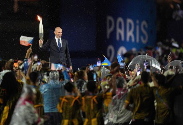 Former French football player Zinedine Zidane holds the Olympic torch during the opening ceremony of the Paris 2024 Olympic Games in Paris on July 26 2024 AFPYonhap