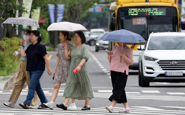 지난 26일 광주 서구 내방로에서 시민들이 갑자기 내리는 비에 우산을 쓰고 걷고 있다 사진연합뉴스