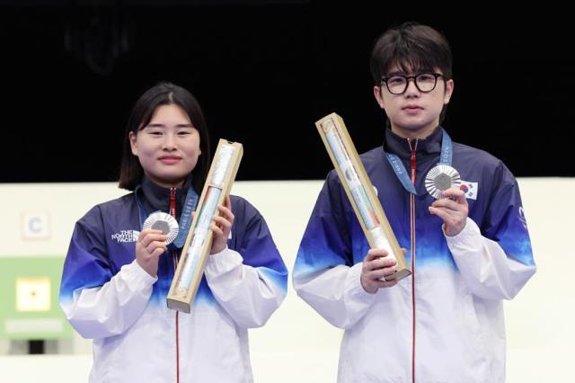 Shooters Nam Ji-hyeon left and Park Ha-jun pose with their silver medals from the 10-meter air rifle mixed team event of the Paris Olympics in France on Saturday