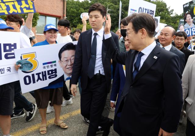 28일 오전 충남 공주 충남교통연수원에서 열린 더불어민주당 당대표·최고위원 후보자 합동연설회에 참석한 이재명 후보가 지지자들에게 인사하며 토론장으로 향하고 있다 사진연합뉴스