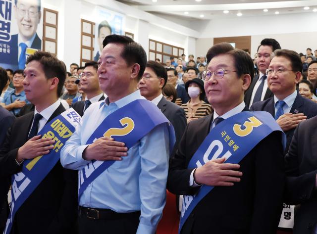 28일 오전 충남 공주 충남교통연수원에서 열린 더불어민주당 당대표·최고위원 후보자 합동연설회에 참석한 당대표 후보들이 국기에 경례하고 있다 사진연합뉴스