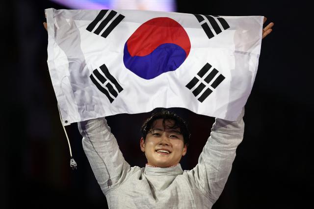 South Korean Oh Sang-uk celebrates after winning against Tunisias Fares Ferjani in the mens sabre individual gold medal bout during the Paris 2024 Olympic Games at the Grand Palais in Paris on July 27 2024 AFP-Yonhap