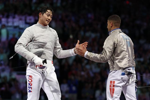 South Korean Oh Sang-uk celebrates after winning against Tunisias Fares Ferjani in the mens sabre individual gold medal bout during the Paris 2024 Olympic Games at the Grand Palais in Paris on July 27 2024 AFP-Yonhap