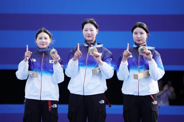 Gold medalist team South Korean Nam Su-hyeonfrom right Lim Si-hyeon Jeon Hun-young poses on the podium after the Women Team matches of the Archery competitions in the Paris 2024 Olympic Games at the Invalides in Paris France 28 July 2024 EPA-Yonhap