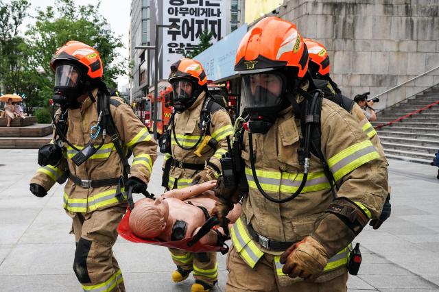 Firefighters practice transporting injured victims on stretchers during Seouls earthquake response drill at Sejong Center for the Performing Arts next to Gwanghwamun Plaza on July 29 2024 AJU PRESS Park Jong-hyeok