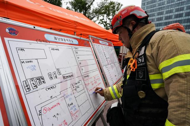 A firefighter prepares an operation map during Seouls earthquake drill at Sejong Center for the Performing Arts next to Gwanghwamun Plaza on July 29 2024 AJU PRESS Park Jong-hyeok