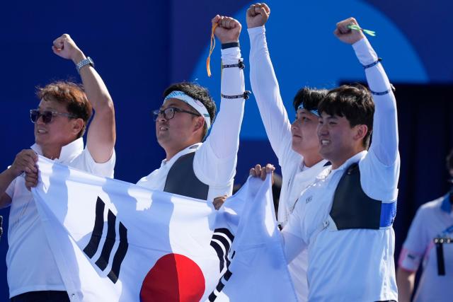 South Koreas Kim Woo-jin center Lee Woo-seok and Kim Je-deok celebrate after a win during the mens team gold medal match Archery competition against France at the 2024 Summer Olympics Monday July 29 2024 in Paris France AP-Yonhap