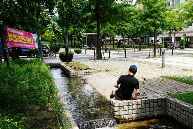 A citizen rests by the waterway at Gyeongui Line Forest Park in Mapo district Seoul on July 31 2024 as the heat index approaches 37 degrees Celsius AJU PRESS Park Jong-hyeok