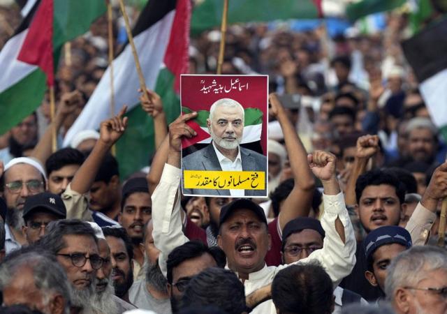 A supporter of the Pakistani religious group Jamaat-e-Islami holds a poster with the portrait of Hamas leader Ismail Haniyeh in Karachi Pakistan during a protest to condemn his killing on July 31 2024 AP-Yonhap 