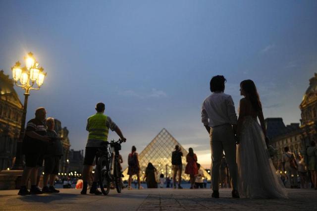 People stand outside the Louvre Museum at the Summer Olympics in Paris France on July 31 2024 AP-Yonhap