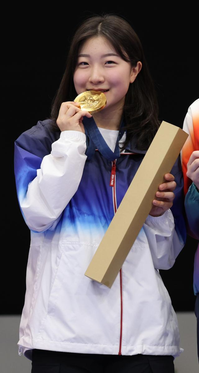 Ban Hyo-jin bites her gold medal won in the womens 10m air rifle final at the Paris Olympics in France July 29 2024 Yonhap