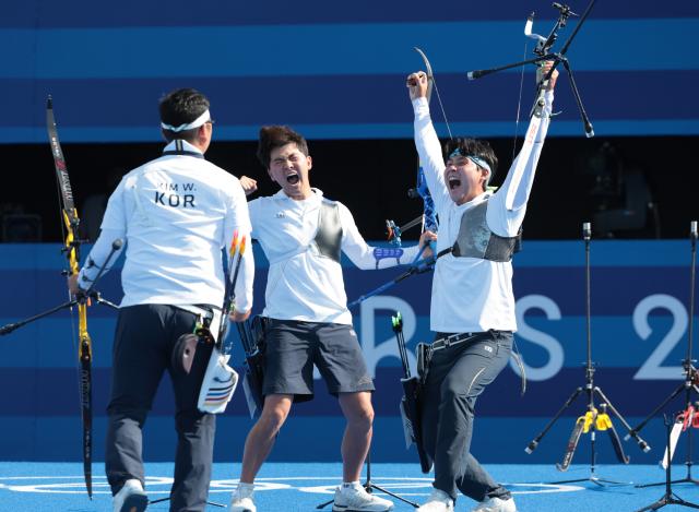 Kim Woo-jinL Kim Je-deok and Lee Woo-seok celebrate after defeating France in the mens team archery final at the Paris Olympics in France July 30 2024 Yonhap