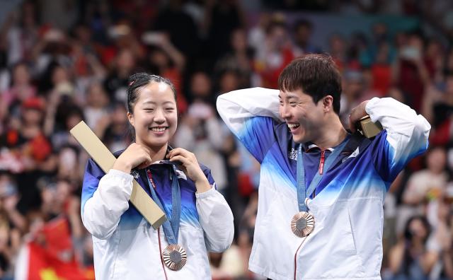 Lim Jong-hoon and Shin Yu-bin celebrate their bronze medal in the mixed doubles table tennis event at the Paris Olympics in France July 30 2024 Yonhap