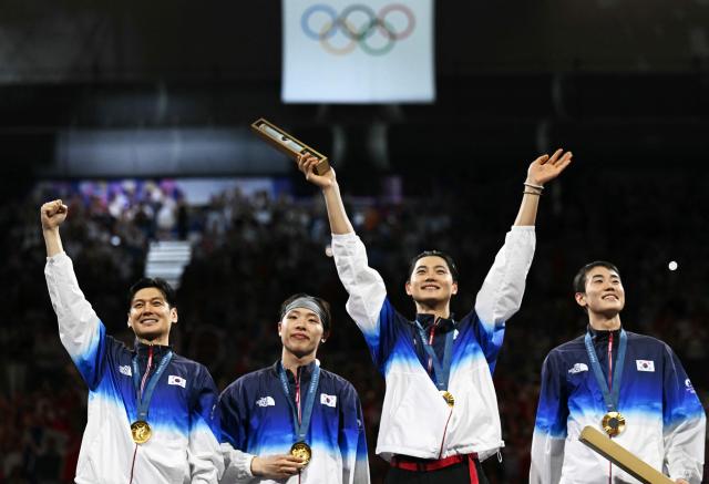 Gu Bon-gil L Park Sang-won Do Gyeongdong and Oh Sang-uk wear their gold medals during the ceremony after winning the mens team sabre fencing competition at the Paris Olympics in France August 1 2024 AFP-Yonhap