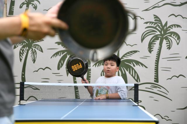 Visitors play table tennis with frying pans at the PUBG pop-up store PUBG Seongsu in Seongsu-dong Seoul on August 1 2024 AJU PRESS Han Jun-gu