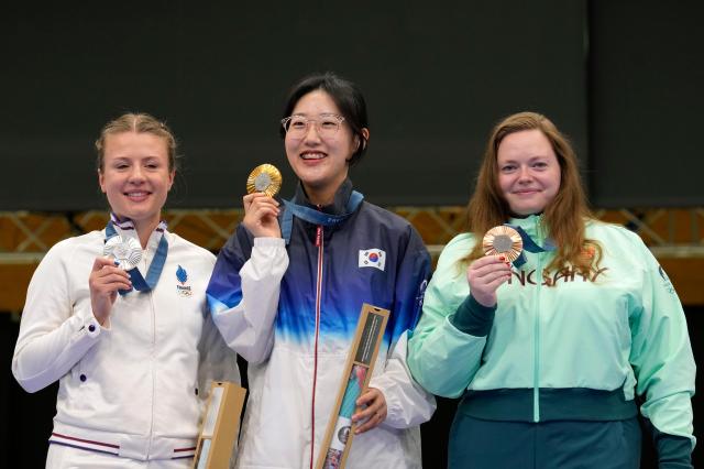 Gold medalist South Koreas Yang Ji-in center poses for a photograph along with silver medalist Frances Camille Jedrezejewski left and bronze medalist Hungarys Veronika Major at the medal ceremony of the 25-meter pistol womens final at the Paris Summer Olympics Saturday Aug 3 2024 in Chateauroux AP-Yonhap