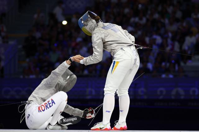 Korean fencer Choi Se-bin left gets up with Ukraines Alina Komashchuk in the womens sabre team bout at the Summer Olympics in Paris France on Aug 4 AFP-Yonhap