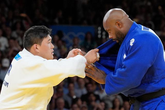 Korean jodoka Kim Min-jong left competes against Frances Teddy Riner in the mens over 100-kg judo category at the Summer Olympics in Paris France on Aug 3 AP-Yonhap