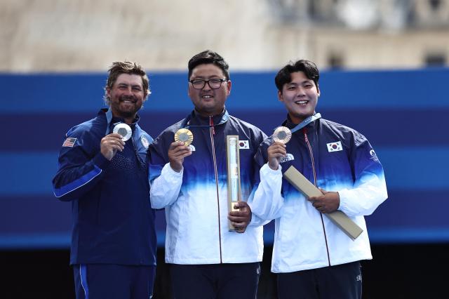 Gold medallist Kim Woo-jin of South Korea celebrates on the podium with silver medallist Brady Ellison of United States and bronze medallist Lee Woo-seok Lee at the medal ceremony at the Paris Olympics Sunday Reuters-Yonhap