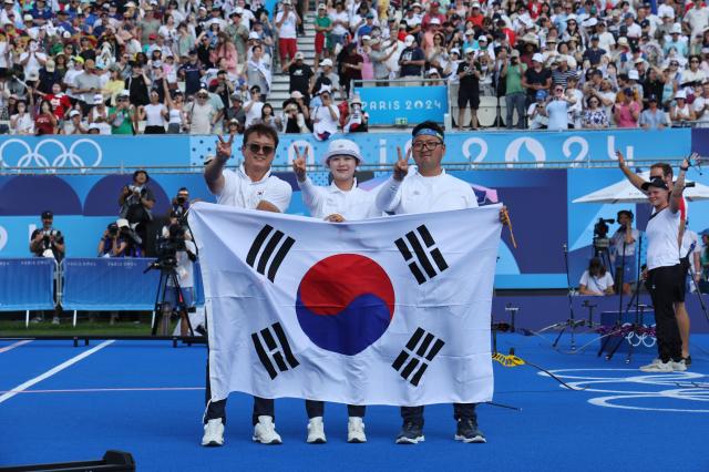 2일한국시간 프랑스 파리 앵발리드에서 열린 2024 파리 올림픽 양궁 혼성 단체 독일과의 결승전에서 승리한 한국 임시현과 김우진이 태극기를 들고 기념사진을 찍고 있다 사진연합뉴스