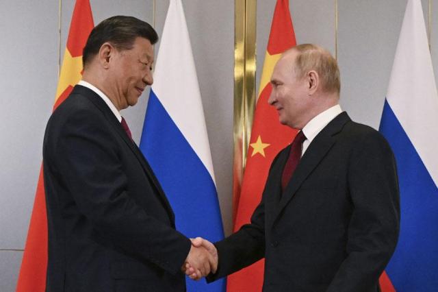 Russian President Vladimir Putin right and Chinese President Xi Jinping shake hands during their meeting on the sidelines of the Shanghai Cooperation Organization SCO summit in Astana Kazakhstan on July 3 2024 AP-Yonhap