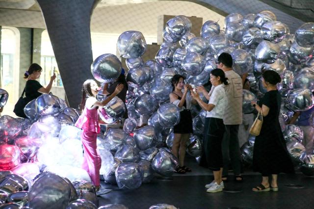 Visitors take a photo at the Mega Boopoo event exhibition at Dongdaemun Design Plaza in Seoul on Aug 5 2024 AJU PRESS Kim Dong-woo