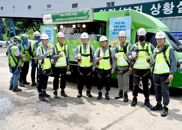 김완석 HJ중공업 대표왼쪽에서 세번째가 현장근로자를 응원하기 위해 제공된 커피차 앞에서 기념사진을 촬영하고 있다 사진HJ중공업 건설부문