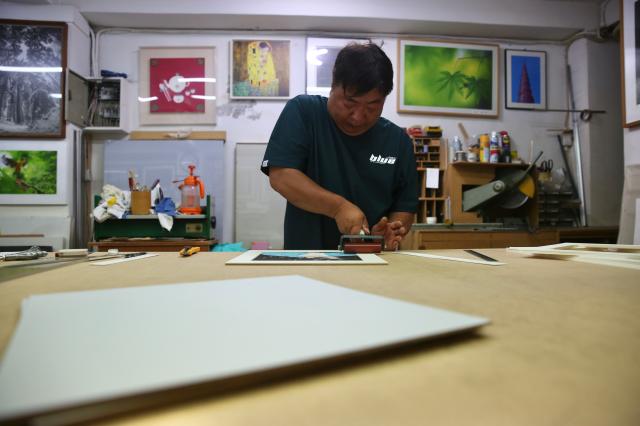 A frame shop worker frames a picture in Chungmuro Seoul on August 5 2024 AJU PRESS Han Jun-gu 