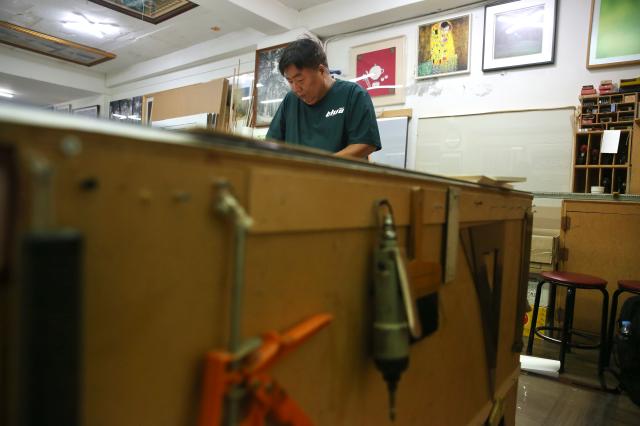 A frame shop worker frames a picture in Chungmuro Seoul on August 5 2024 AJU PRESS Han Jun-gu 