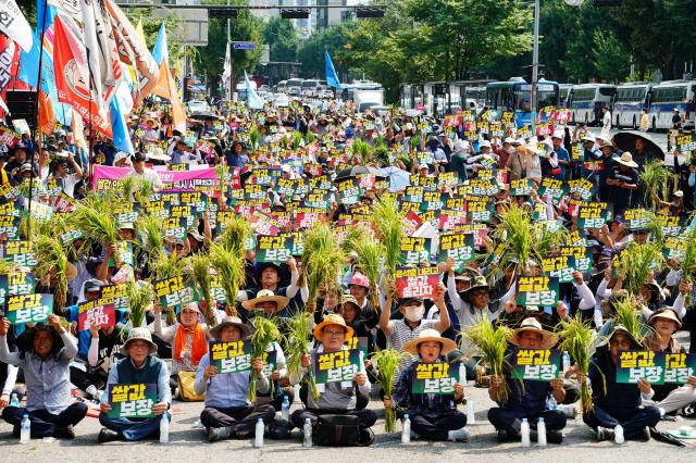 Farmers hold rice plants and placards during a rally organized by the National Farmers Federation to demand guaranteed rice prices on Aug 6 2024 AJU PRESS Park Jong-hyeok