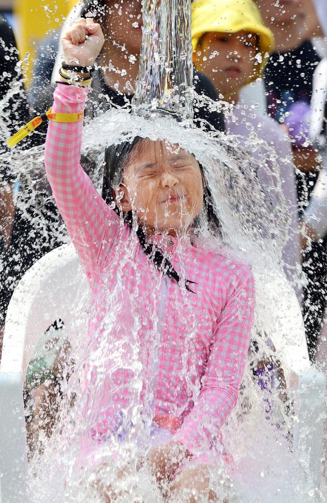 A girl cools off by standing under a waterfall during a festival in Pyeongchang-gun Gangwon Province Wednesday Courtesy of Pyeongchang-gun