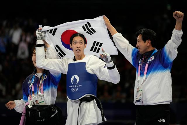 Koreas Kim Yu-jin celebrates with her coaches after winning the gold medal in the womens 57kg taekwondo final match against Irans Nahid Kiyanichandeh during the 2024 Summer Olympics at the Grand Palais in Paris Aug 8 2024 AP-Yonhap