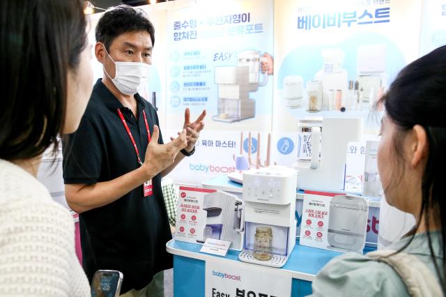 A booth representative explains products at the Global Baby Fair held at COEX in Seoul on Aug 8 2024