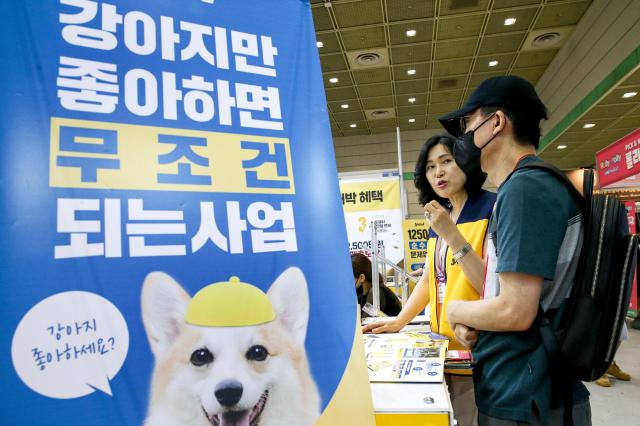 An official explains entrepreneurship to a visitor at the 74th World Franchise Expo held at COEX in Seoul on Aug 8 2024 AJU PRESS Kim Dong-woo