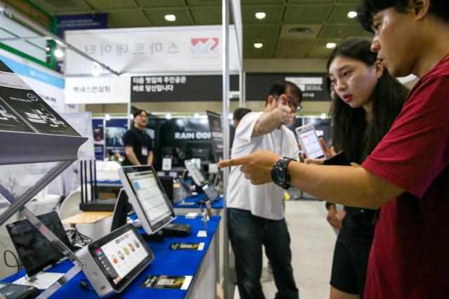 An official explains a product to a visitor at the 74th World Franchise Expo held at COEX in Seoul on Aug 8 2024 AJU PRESS Kim Dong-woo