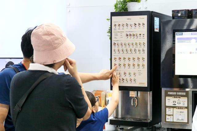 Visitors look at an automated coffee machine on display at the 74th World Franchise Expo held at COEX in Seoul on Aug 8 2024 AJU PRESS Kim Dong-woo