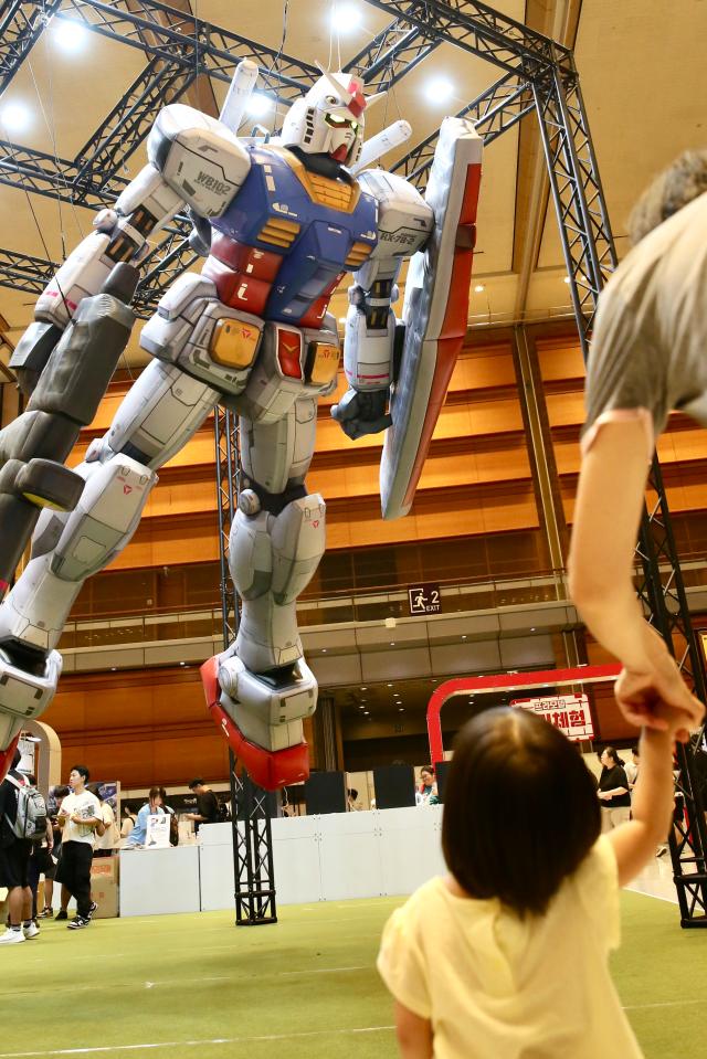 A child looks up at a giant robot on display at the Bandai Namco Korea FUN EXPO 2024 at COEX in Seoul on Aug 9 2024 AJU PRESS Han Jun-gu