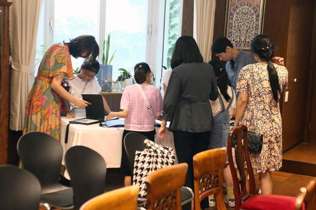 Young students from the Sundukwon Child Welfare Center watch each others photographs during a photo exhibition held at the Indian Ambassador to the Republic of Koreas residence near central Seoul on August 10 Aju Press Park Sae-jin