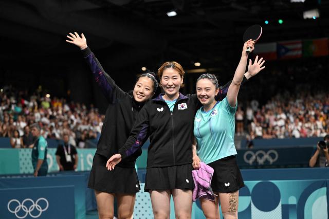 South Koreas Jeon Ji-hee R South Koreas Lee Eun-hye C and South Koreas Shin Yu-bin L celebrate after South Korea won the womens table tennis team bronze medal match between South Korea and Germany at the Paris 2024 Olympic Games at the South Paris Arena in Paris on Aug 10 2024 AFP-Yonhap