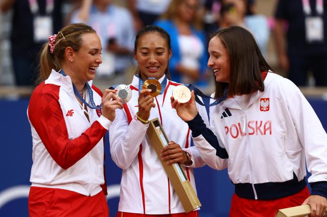 Gold medalist Qinwen Zheng of China silver medalist Donna Vekic of Croatia and bronze medalist Iga Swiatek of Poland pose with their medals after the Womens Singles Victory Ceremony at Roland-Garros Stadium in Paris on August 3 REUTERS-Yonhap