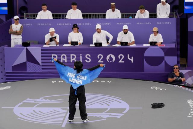 Refugee Teams Manizha Talash known as Talash wears a cape which reads free Afghan women as she competes during the B-Girls Pre-Qualifier Battle at the breaking competition at La Concorde Urban Park at the 2024 Summer Olympics August 9 2024 AP-Yonhap