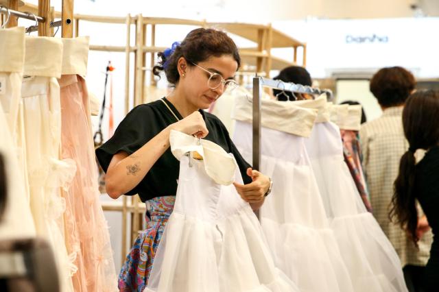 A staff member arranges hanbok at the Hanbok Expo held at Dongdaemun Design Plaza in Seoul on Aug 9 2024 AJU PRESS Kim Dong-woo